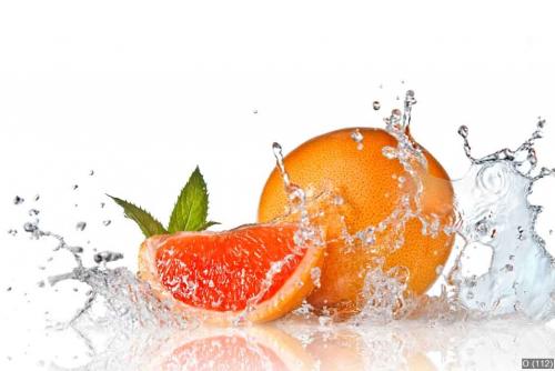 Water splash on grapefruit with mint isolated on white