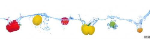 Tropical fruits and vegetables falling into water with splash