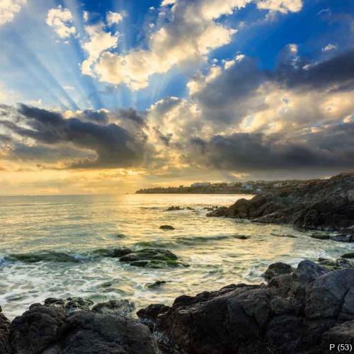 sea wave breaks about boulders at sunrise