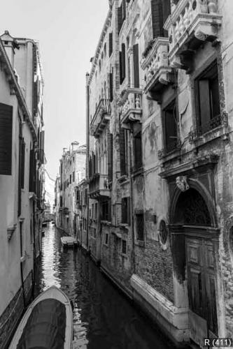 Black and white Venice channel with aged ruined buildings